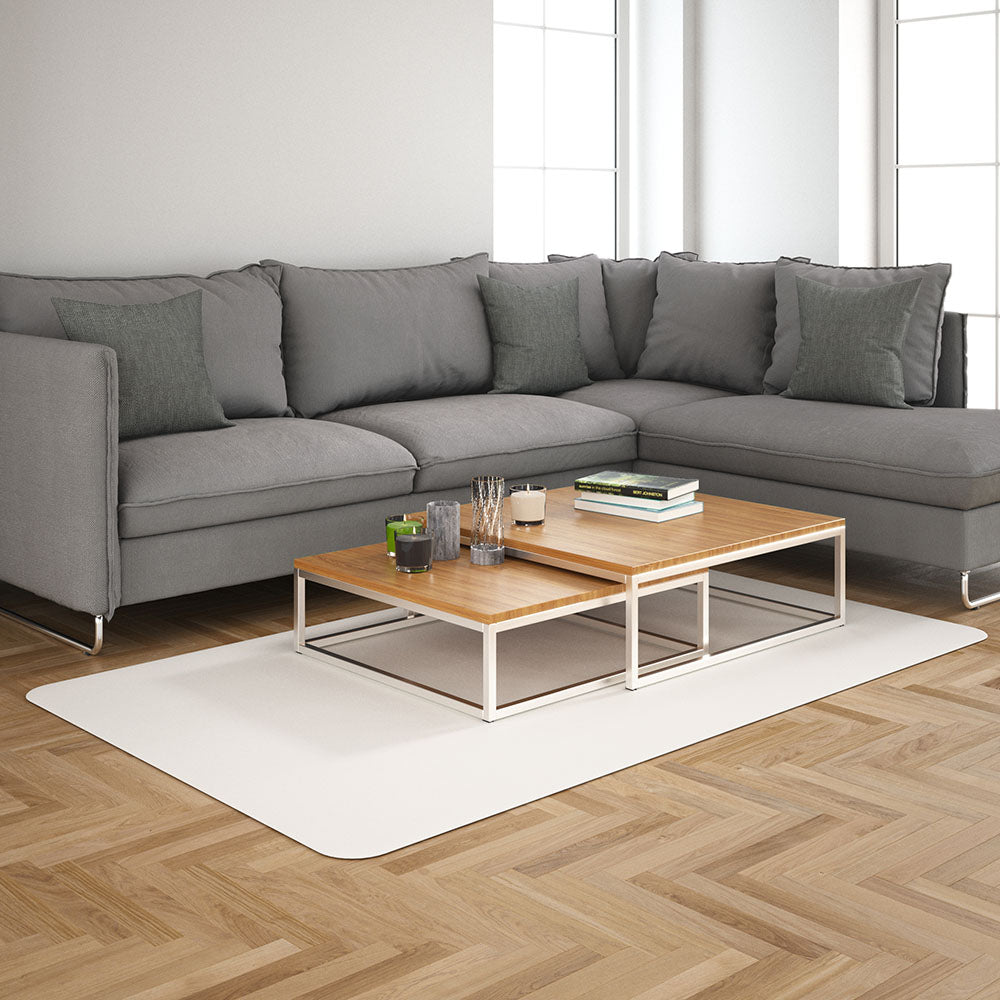 Gray sectional sofa with multiple cushions and a two-tier wood coffee table on a beige rug in a bright living room.