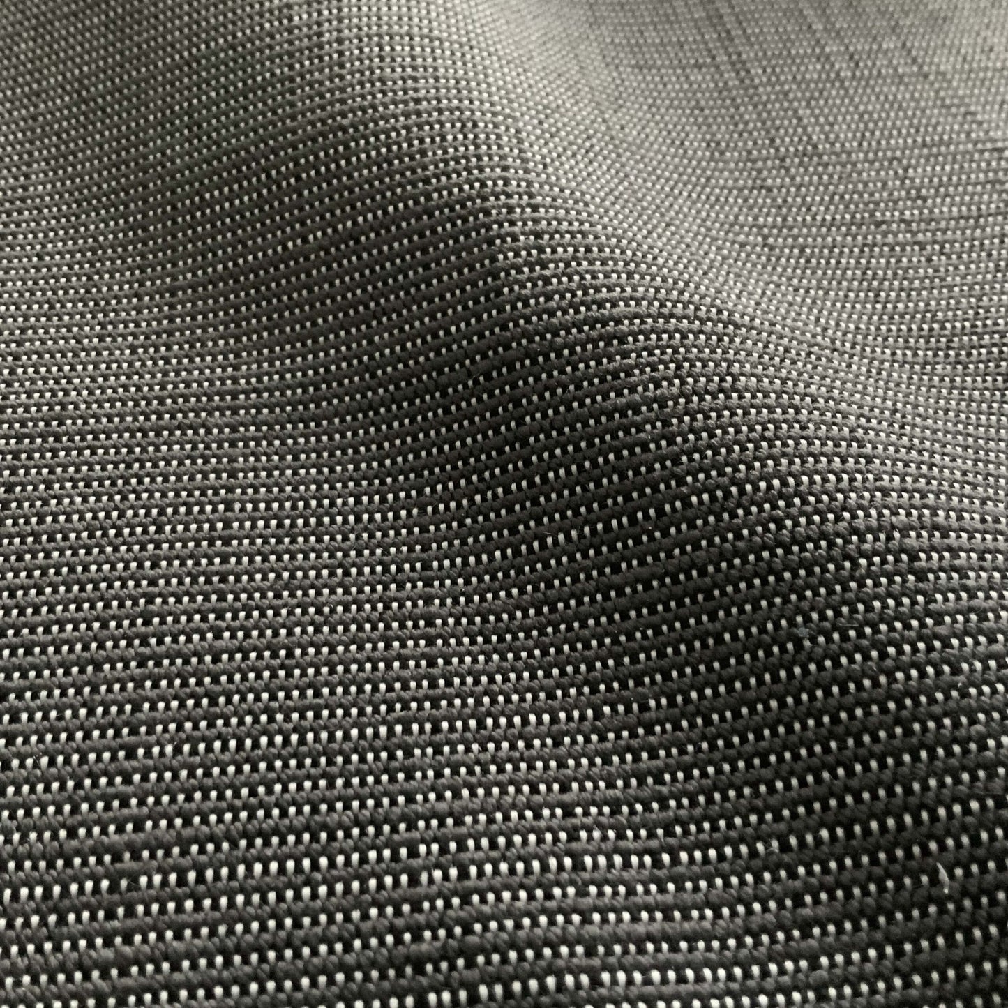 Close-up of charcoal gray, tightly woven outdoor fabric with a linen texture.