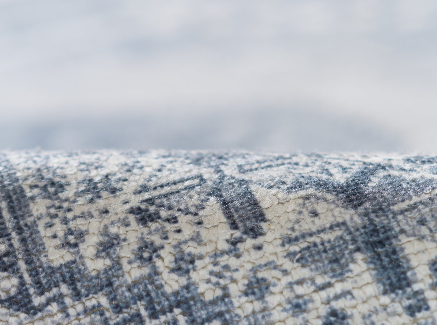 Close-up of blue and ivory geometric runner with textured, cracked weave.