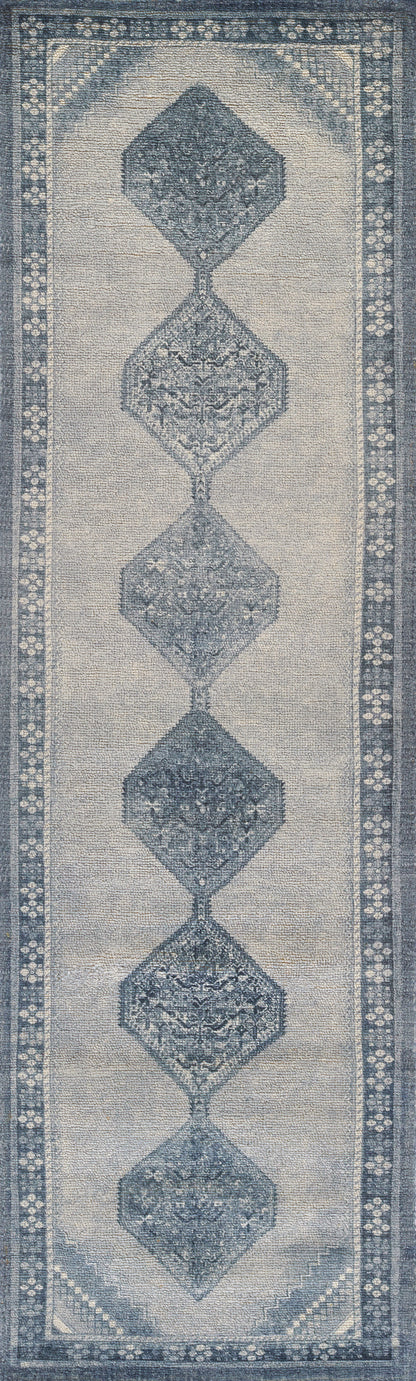 Blue-gray runner rug featuring stacked diamond medallions on a beige field with a floral border.