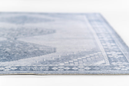 Blue rectangular rug with subtle vintage geometric pattern and light border, soft woven texture for living room decor.