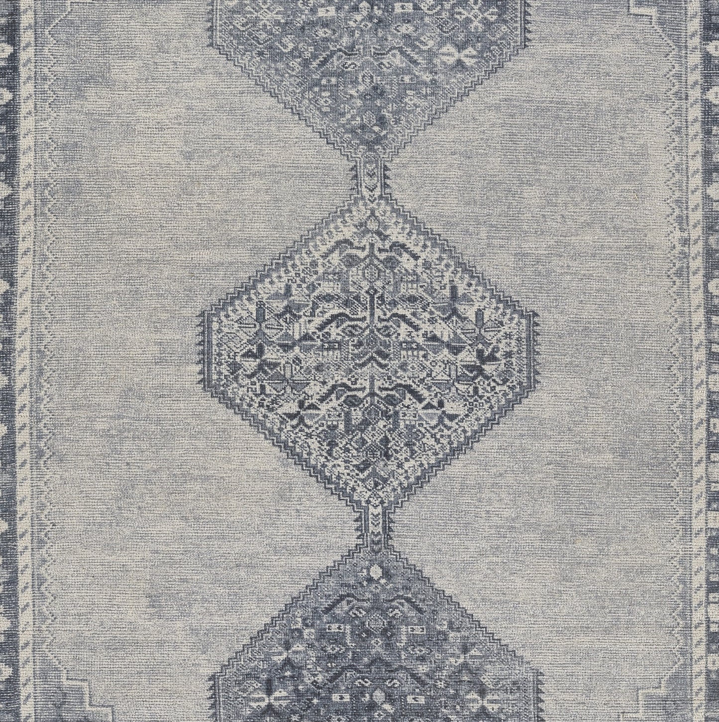 Blue-gray oriental rug with three connected diamond medallions, intricate floral motifs and a decorative border.