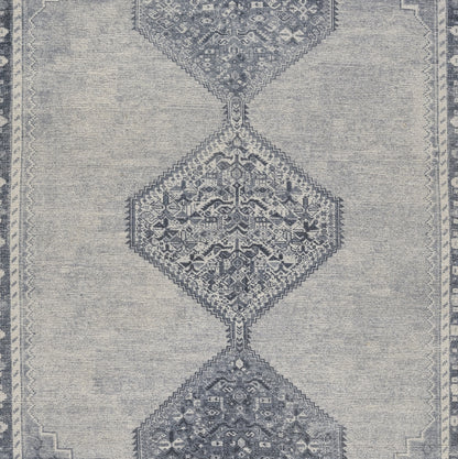 Blue-gray rug with linked diamond medallions, intricate floral motifs, and a subtle bordered edge.