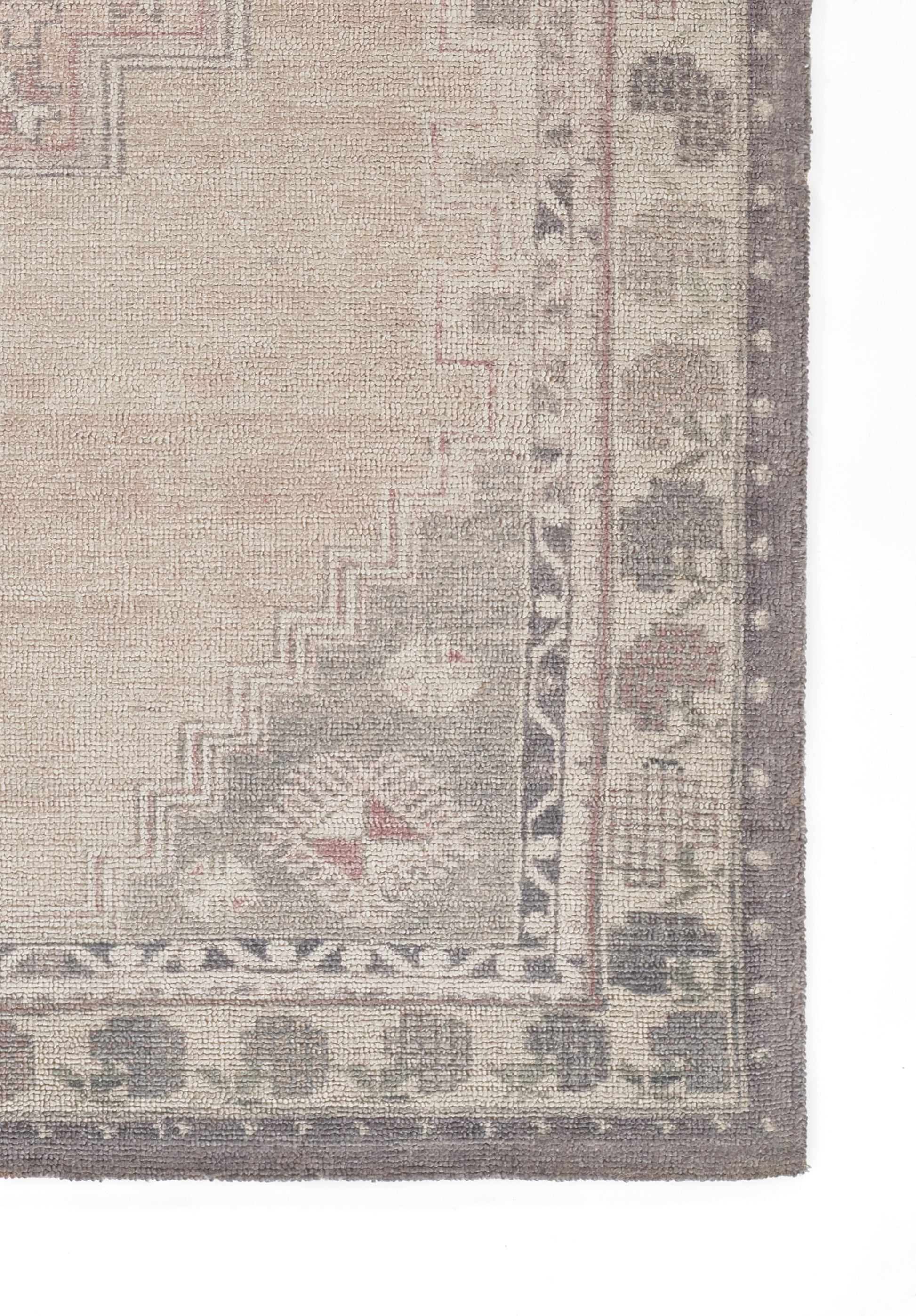 Beige distressed oriental rug with taupe border and soft red accents; woven geometric pattern.
