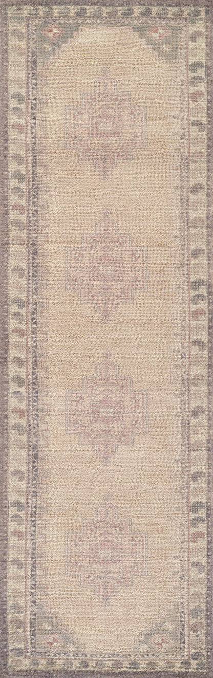 Beige oriental rug with soft pink central medallions and muted blue-gray border; woven texture.