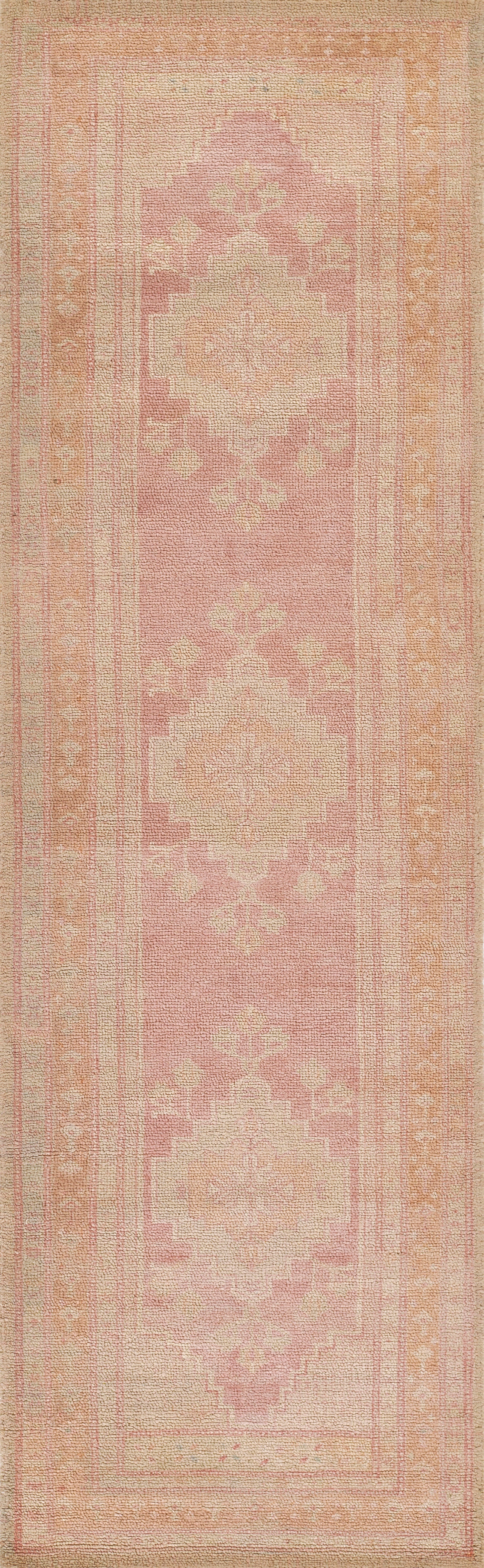 Pink 2' x 4' rug with cream geometric medallions in a vintage oriental pattern and a soft pastel border.