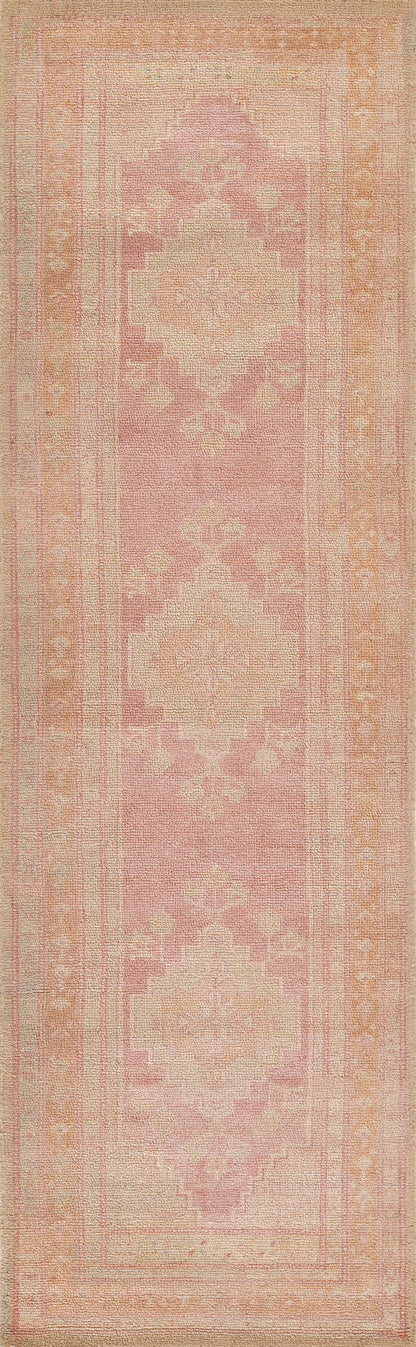 Pink 2' x 4' rug with cream geometric medallions in a vintage oriental pattern and a soft pastel border.
