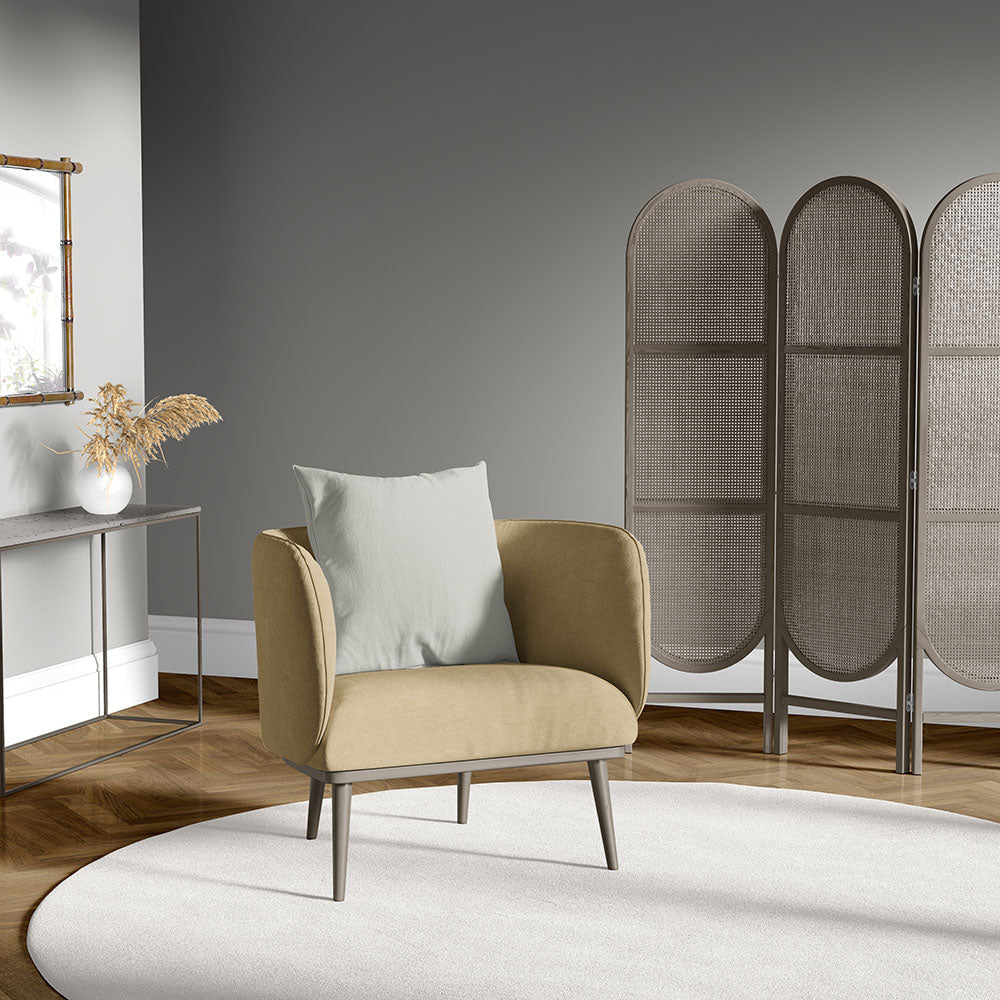 Mustard armchair with light gray cushion, slim legs in a modern living room with a three-panel woven screen, round white rug.