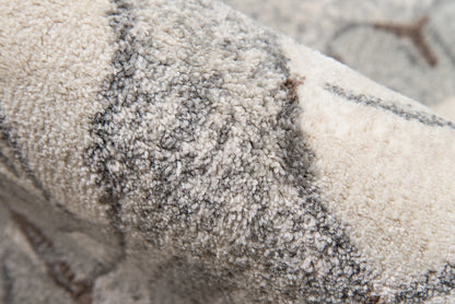 Close-up of a plush beige-gray rug with dense shag pile and subtle geometric lines.