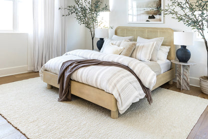 Beige 5' x 8' rug with a subtle pattern in a bright coastal room.