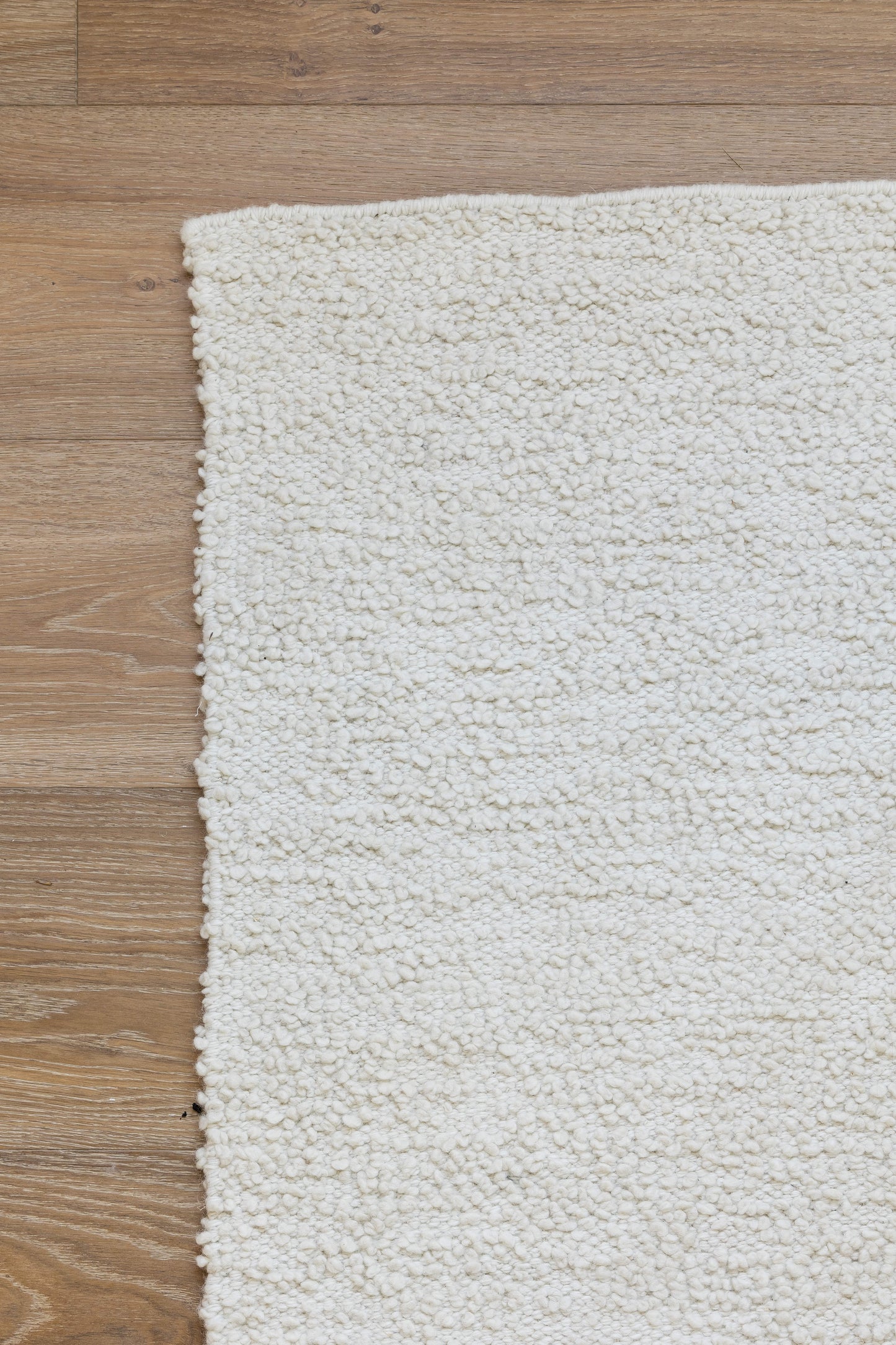 Ivory shag rug with fluffy, textured pile on a wooden floor; rectangular, cozy home decor accessory