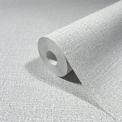 Gray textured wallpaper roll with woven fabric-like pattern, partially unrolled to reveal the cardboard core.