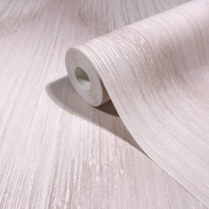 Roll of light beige wallpaper with subtle wood-grain texture, partially unrolled on pale wooden surface.