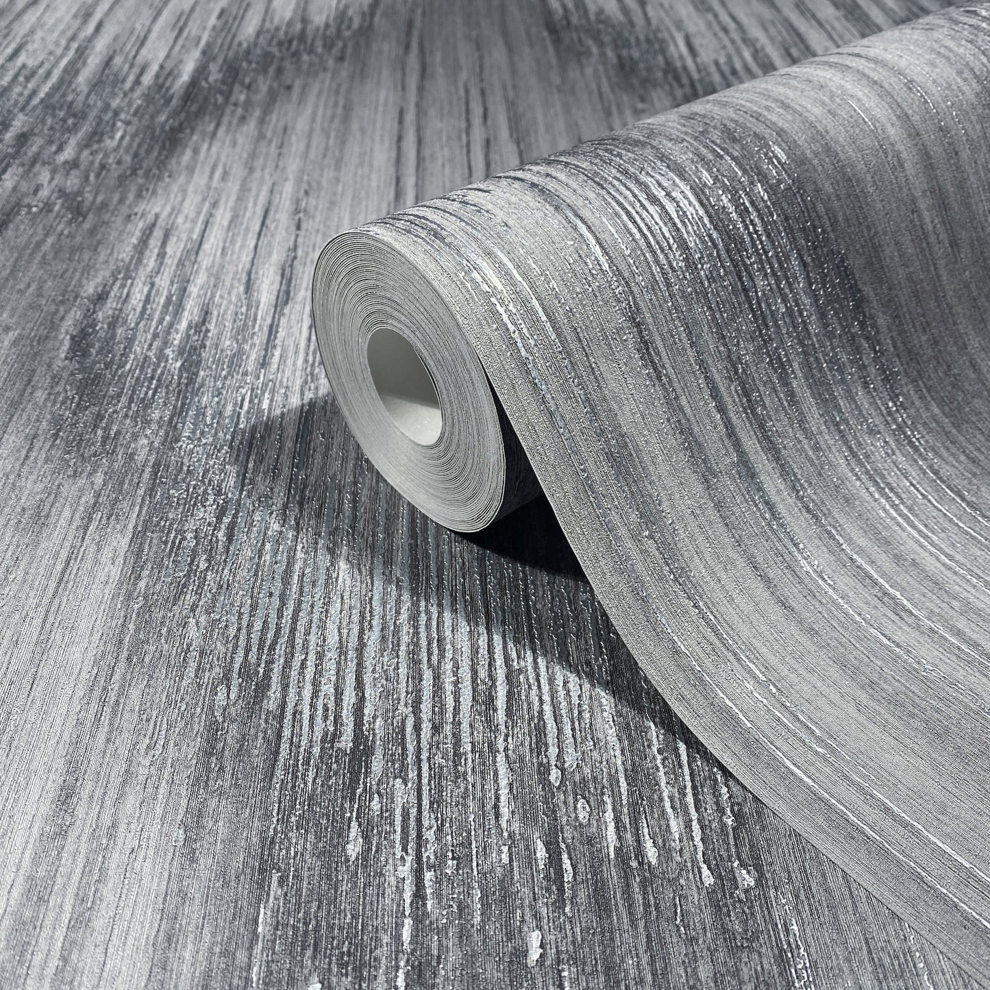 Rolled grey textured flooring sample with silver-white linear streaks, partially unrolled to reveal brushed surface.