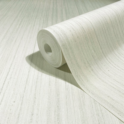 Light gray textured wallpaper roll unfurling on pale surface with subtle linear pattern.