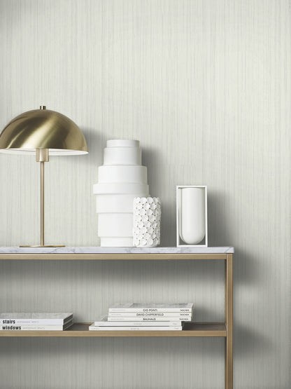 Brass dome table lamp with white ceramic vases on a marble-topped brass shelf, stacked books beneath.