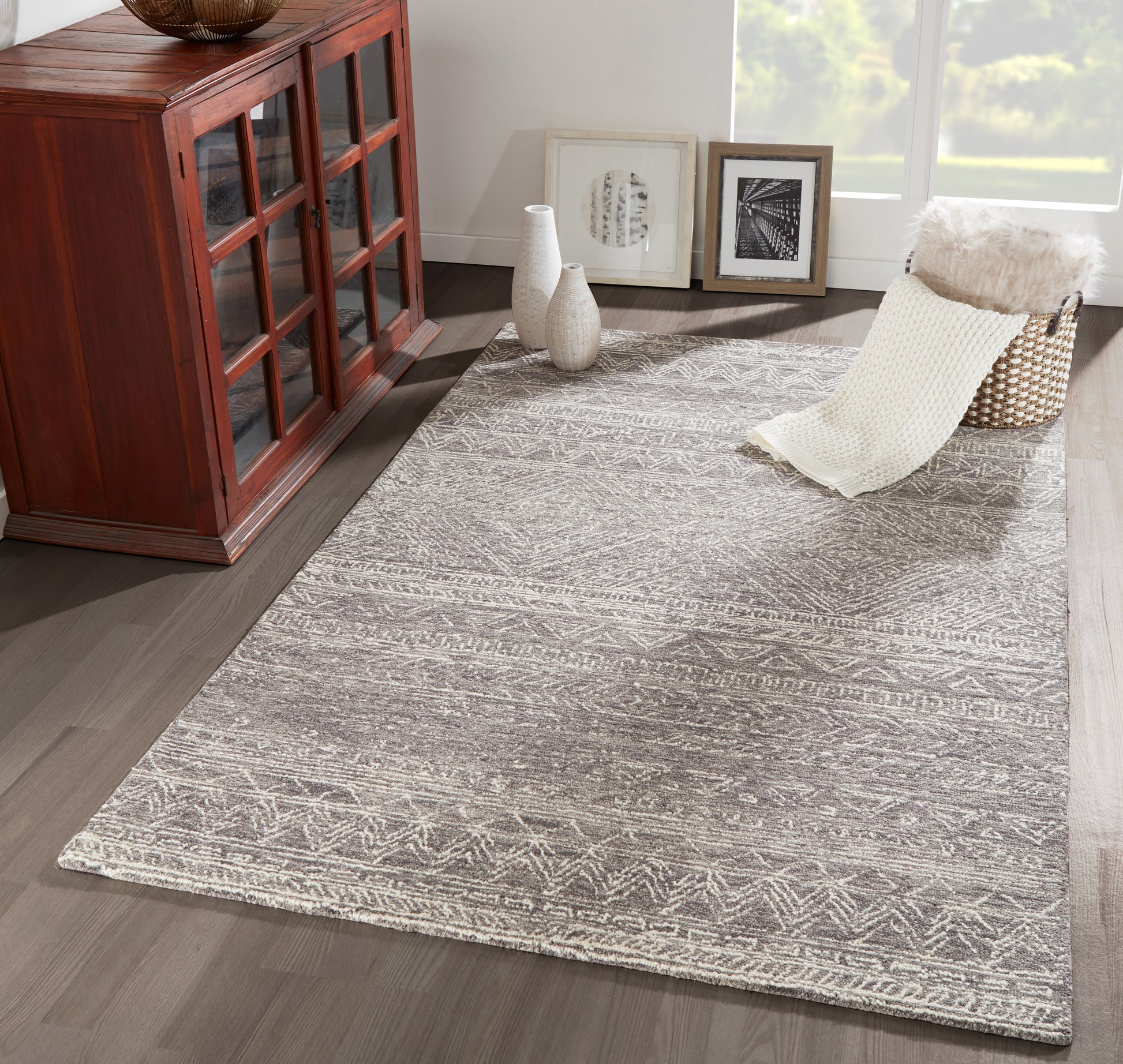 Grey geometric flatweave area rug with white tribal motifs, suitable for a modern living room.