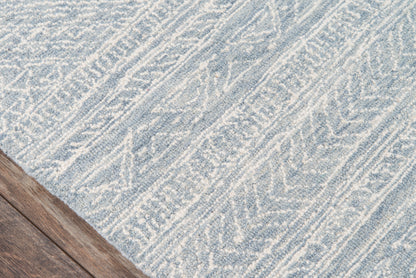 Blue and white textured rug with abstract geometric pattern on a dark wood floor.