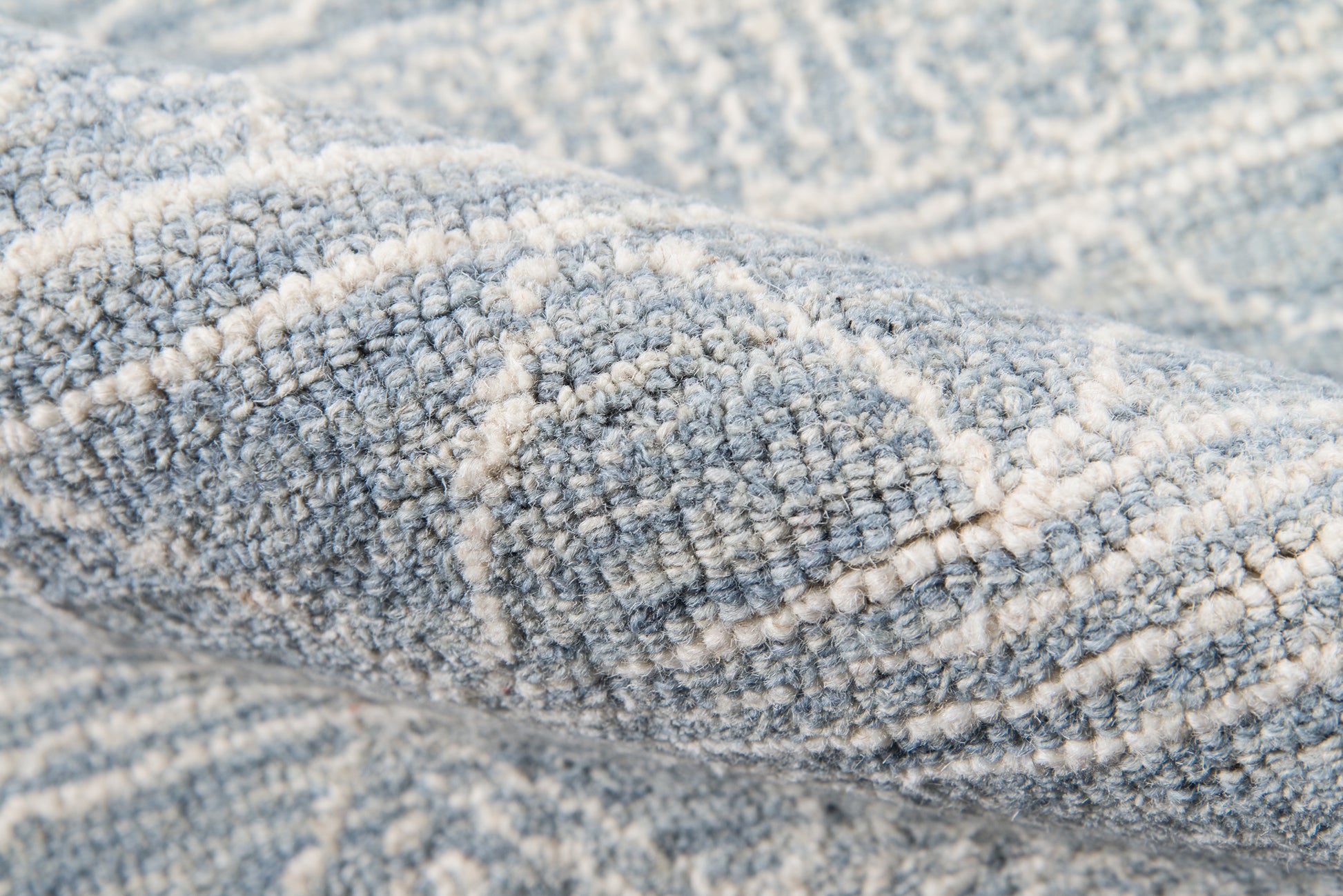 Close-up of blue-gray & white striped boucle rug with soft, woven pile for cozy home decor.