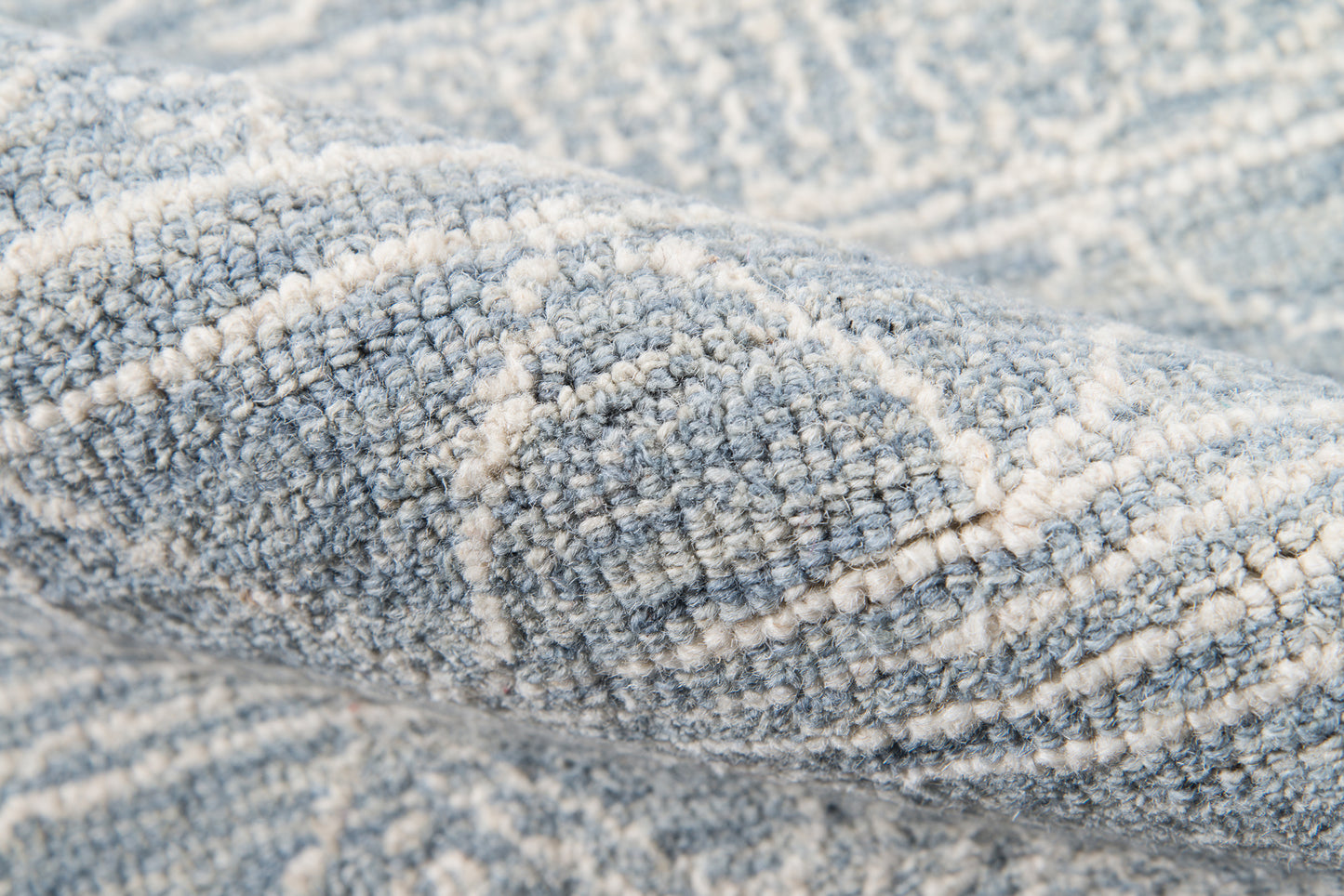 Close-up of a blue-gray striped rug runner with cream lines; dense, soft pile for cozy, modern decor.