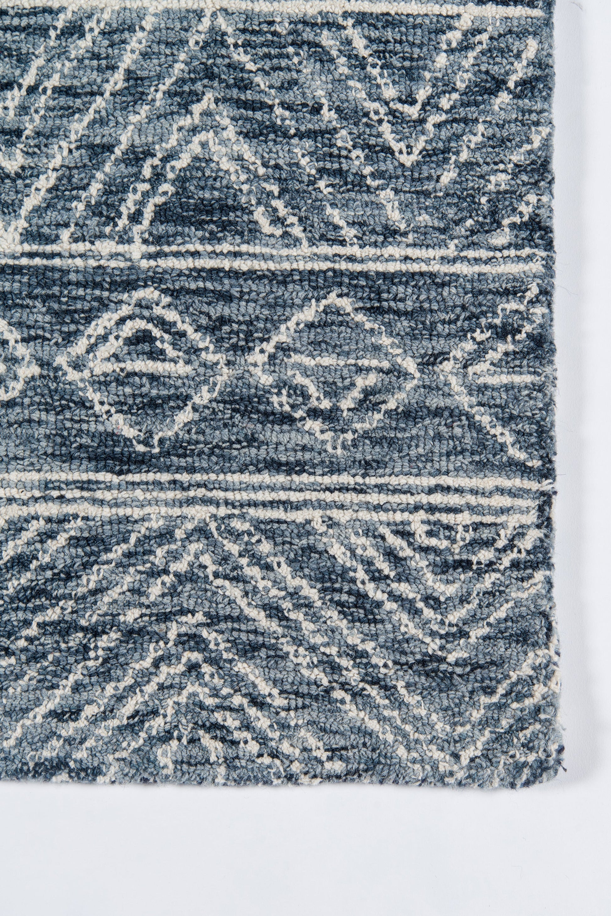 Navy blue rug with off-white geometric diamonds; plush woven texture, boho & tribal style for living room or hallway.