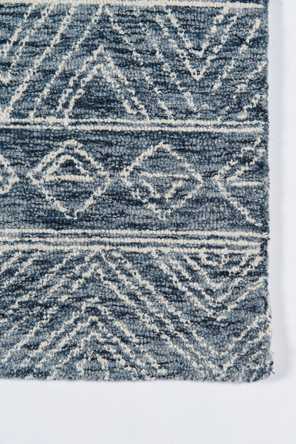 Blue & white geometric rug with diamond motifs & shaggy pile; tribal-inspired casual decor.