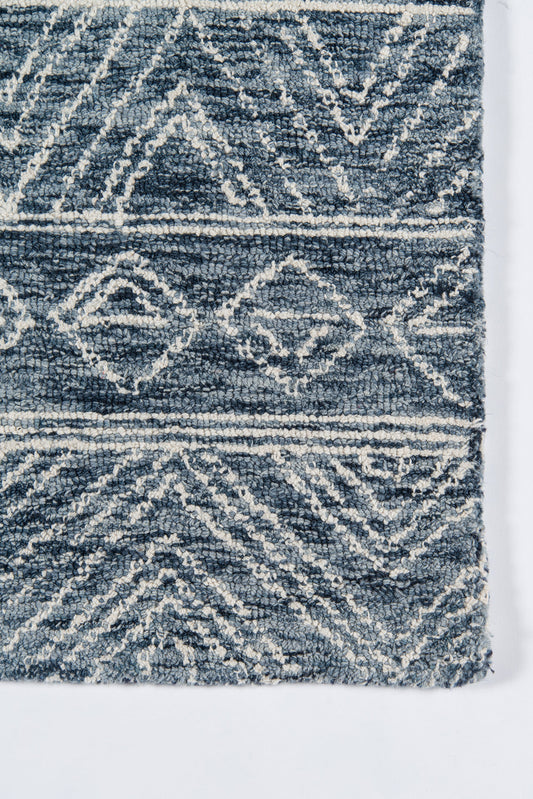 Blue & white geometric rug with diamond motifs & shaggy pile; tribal-inspired casual decor.