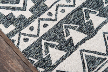 Navy and white geometric tribal rug with triangles and chevrons on a wood floor