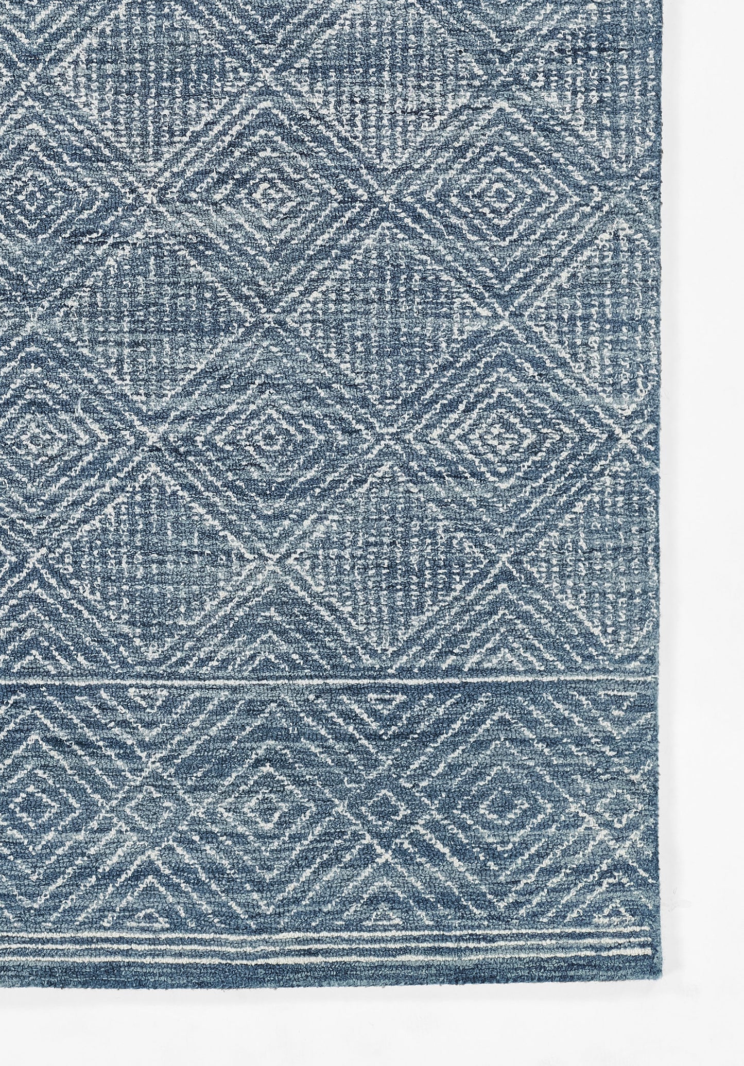 Blue textured rug with white geometric diamond lattice pattern and a light border.