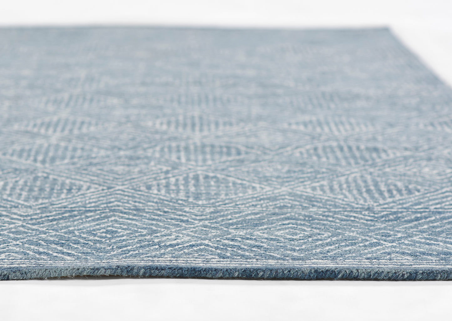 Blue woven rug with white geometric lattice diamond pattern & fringe edge.