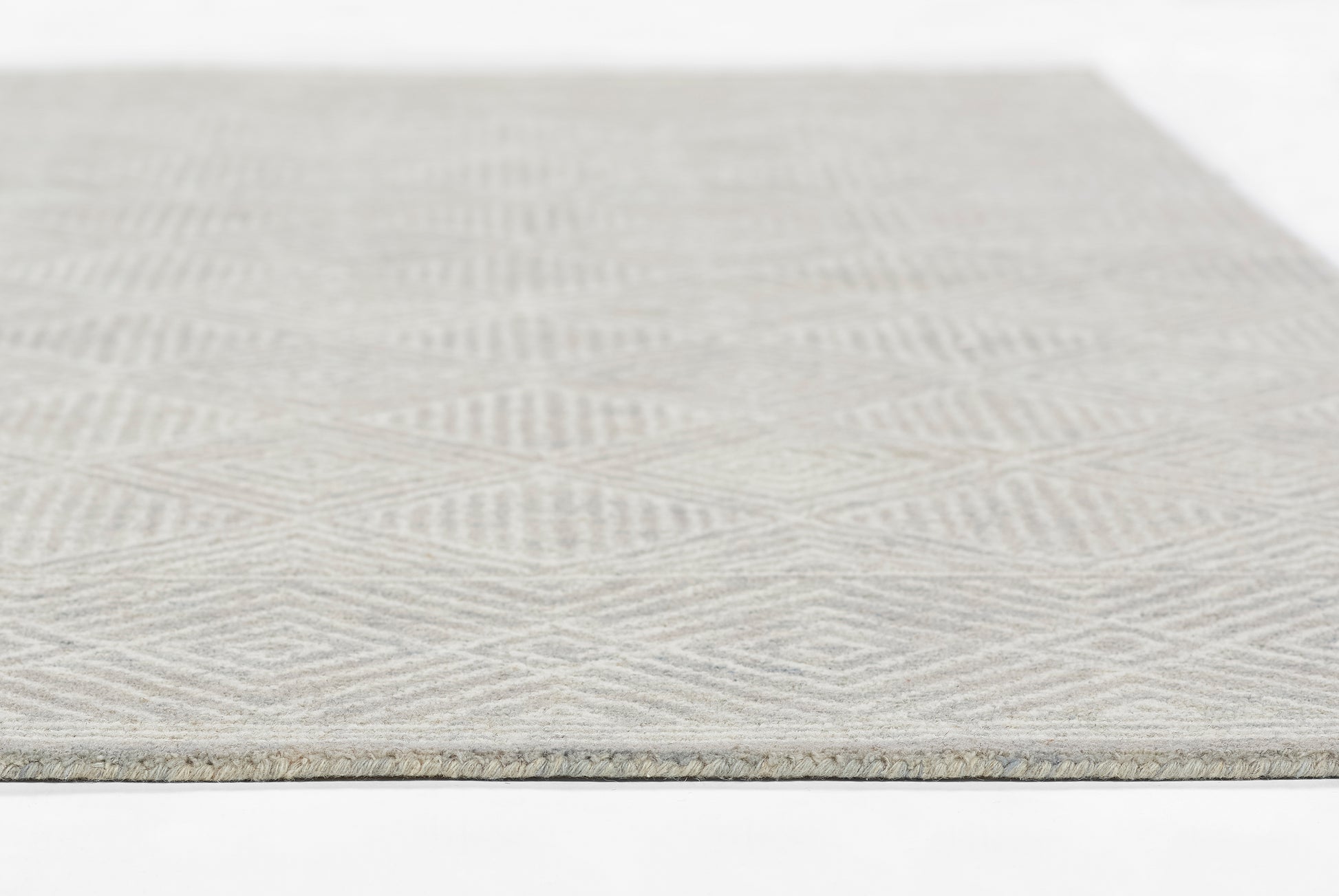 Light gray textured rug with a repeating chevron pattern; rectangular, soft woven surface for living spaces.