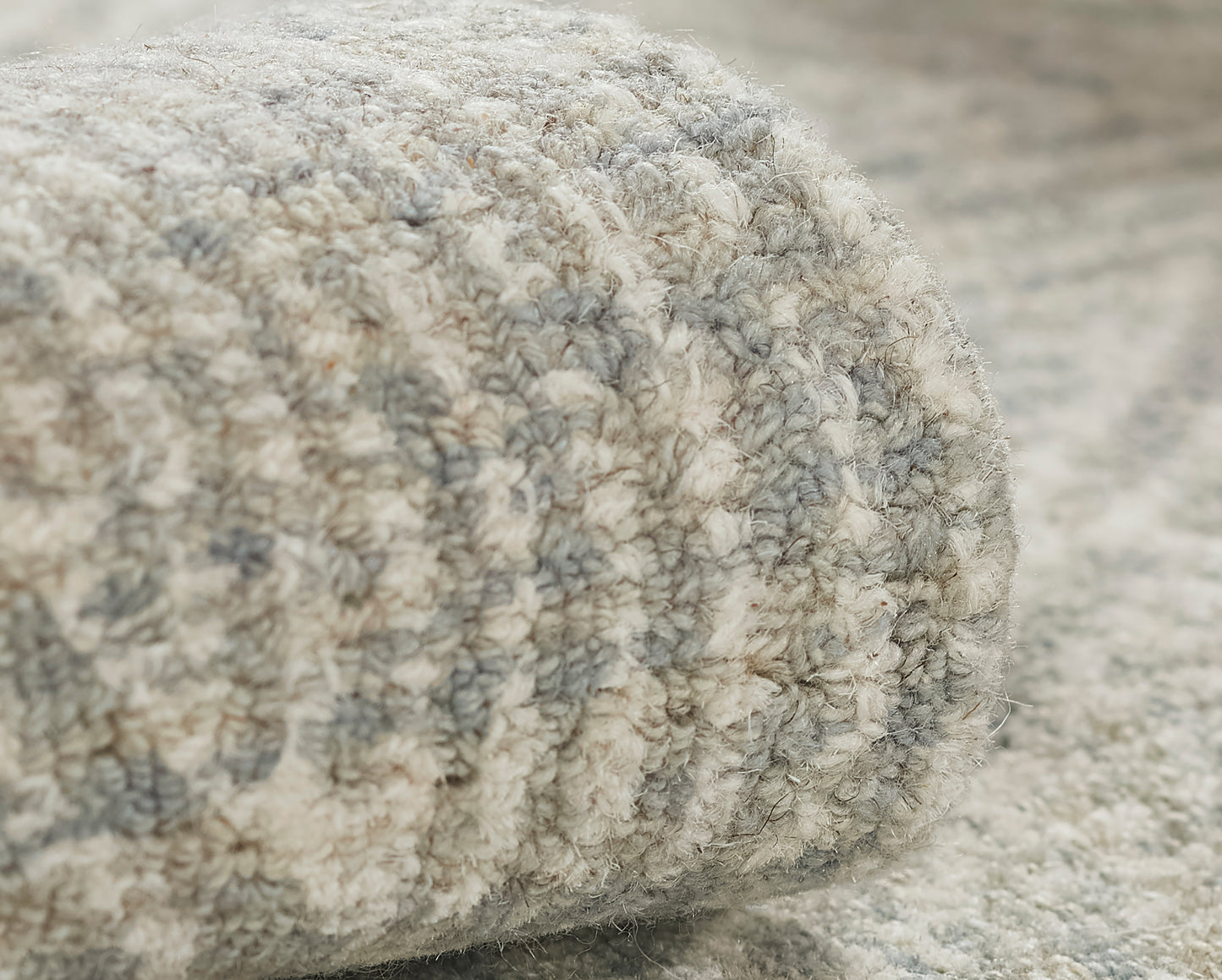 Close-up of a soft gray and ivory shag rug with thick looped pile, cozy living-space decor.