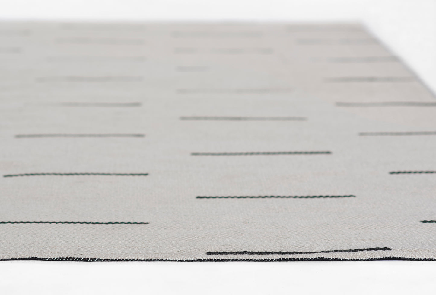 Gray rectangular rug with evenly spaced black horizontal lines; modern minimalist design.