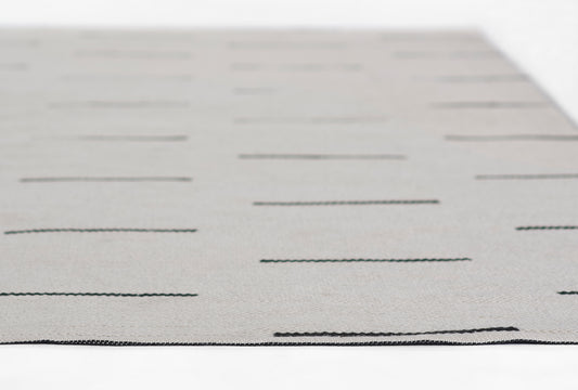 Gray rectangular rug with evenly spaced black horizontal lines; modern minimalist design.