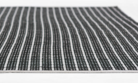 Rectangular woven rug with black and white narrow vertical stripes, casual flat-weave.