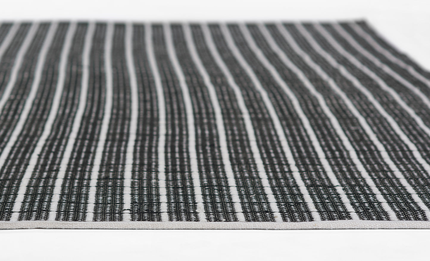 Woven black-and-white striped rug runner with textured weave.