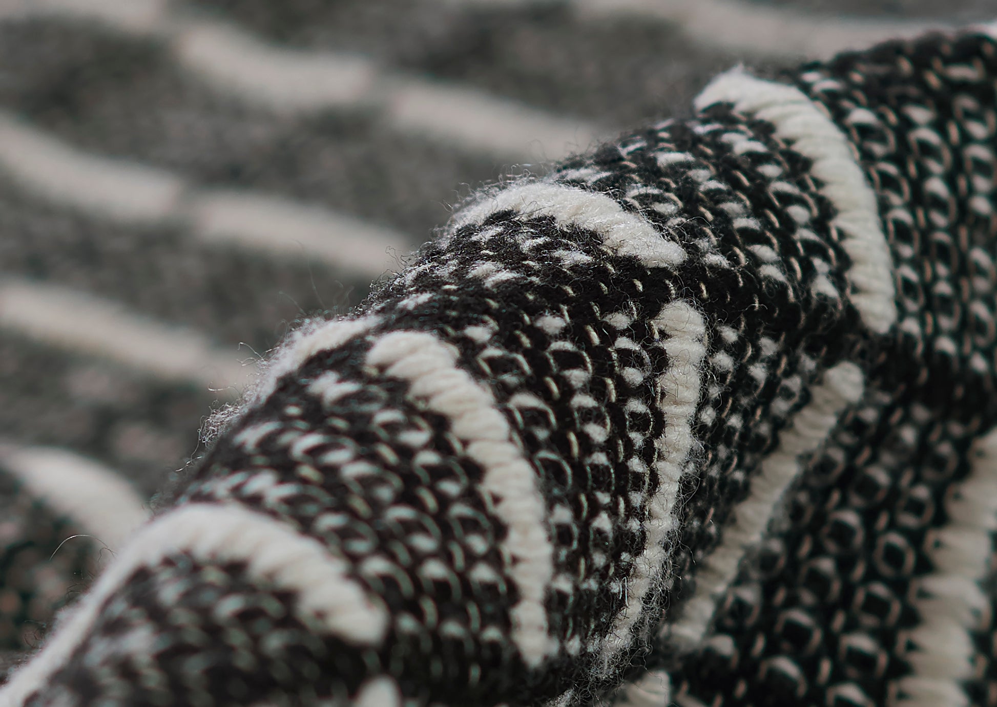 Close-up of black & white boucle woven rug with bold striped pattern and chunky texture.