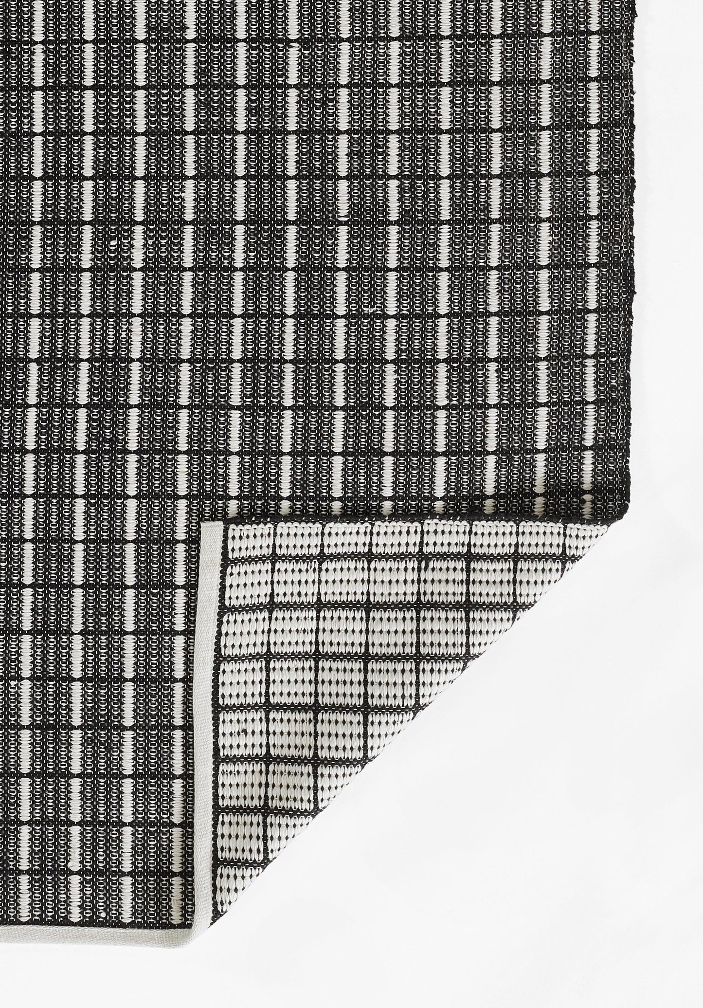 Gray gradient rug with a black-and-white woven strip at the bottom left and a white triangular corner.