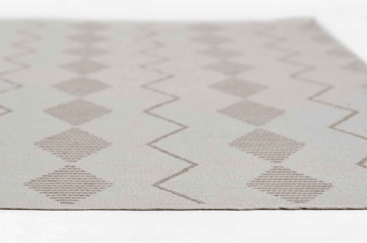 Beige runner rug with taupe diamonds and zigzag stripes in a woven texture, 2' x 8'.