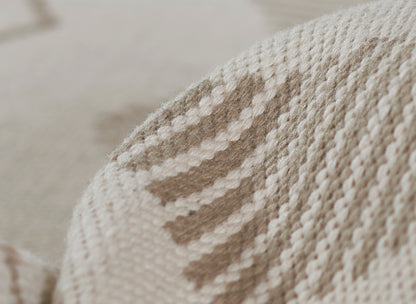 Chunky knit throw blanket in beige and ivory stripes; soft woven texture.