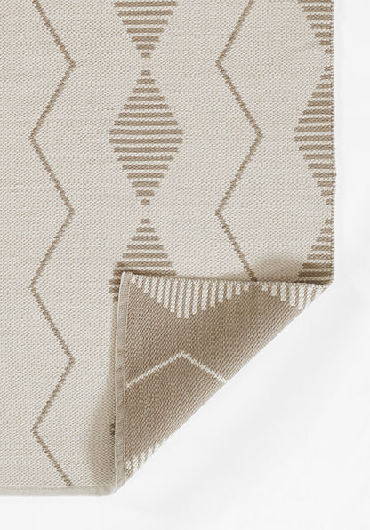 Beige woven rug with taupe diamond and zigzag pattern; textured surface, folded corner showing underside.