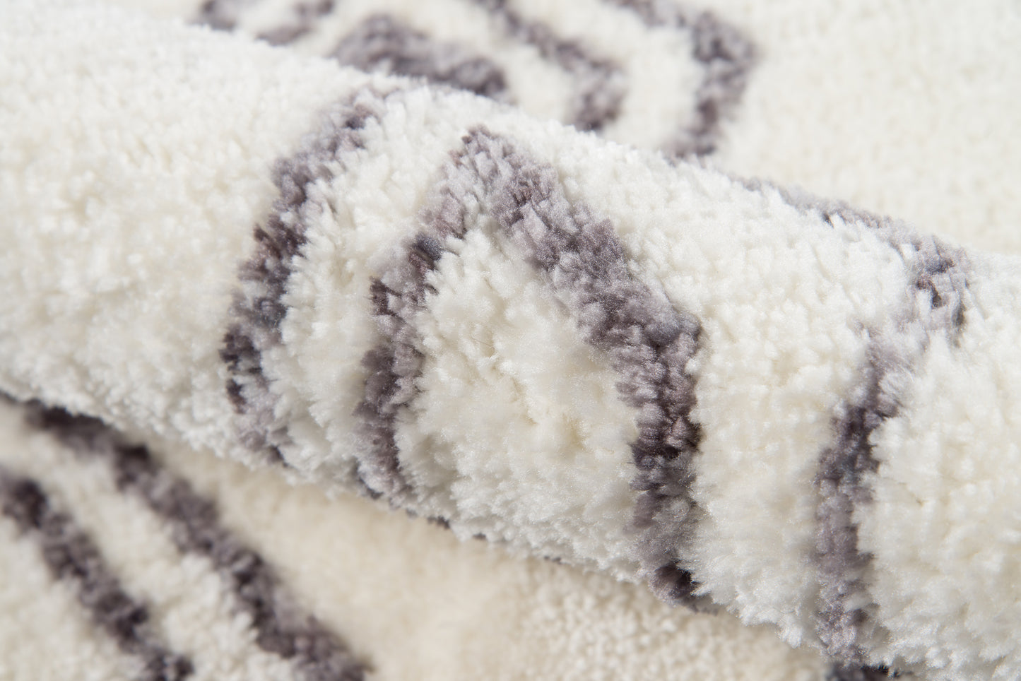 Cream shag rug with gray diamond stripe pattern, plush fluffy pile for cozy living spaces.