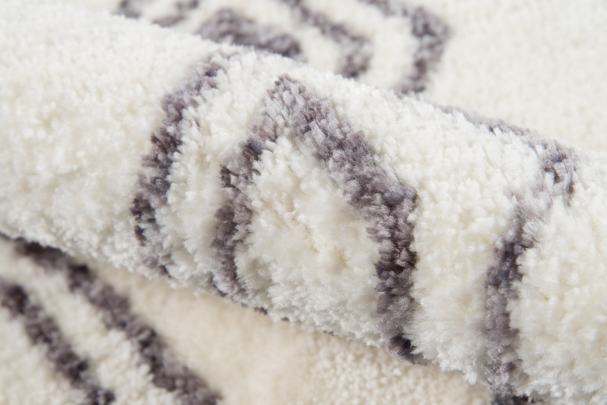 Cream shag rug with gray diamond stripe pattern, plush fluffy pile for cozy living spaces.