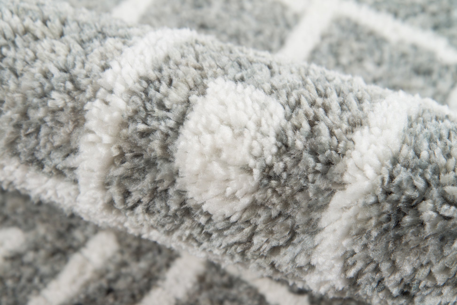 Soft gray & white shag rug close-up; plush pile with striped pattern for cozy living-room decor.
