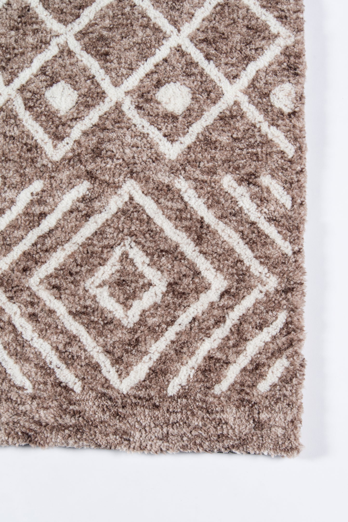 Brown shag rug with white diamond geometric pattern; plush, textured surface.