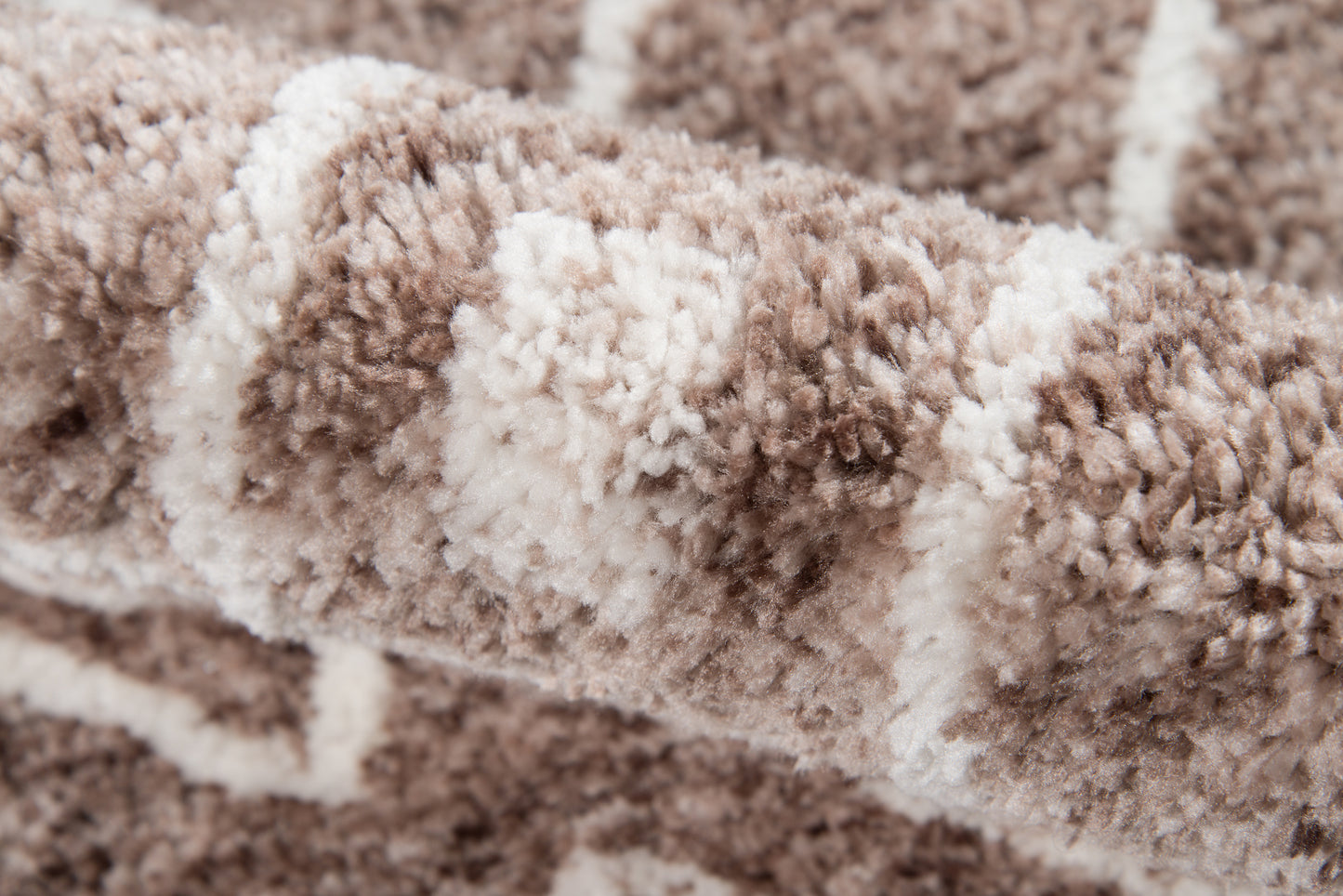 Close-up of a plush brown and beige shag rug with cream stripes and a soft, high-pile texture.