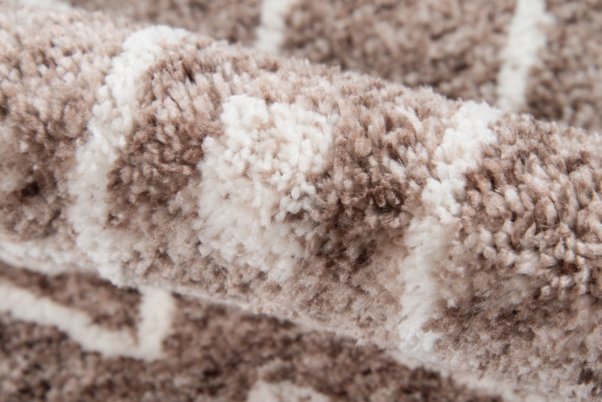 Close-up of a plush brown and beige shag rug with cream stripes and a soft, high-pile texture.