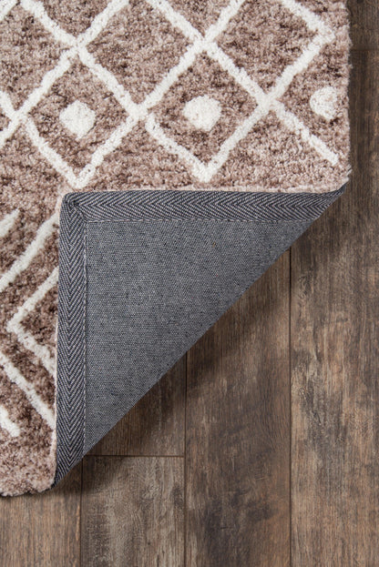Brown shag rug with white geometric lattice pattern; folded corner reveals denim-gray backing on wood floor.