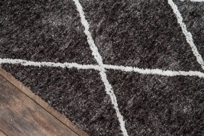 Charcoal shag rug with thick white grid lines on a wood floor, creating a geometric, cozy living-room accent.