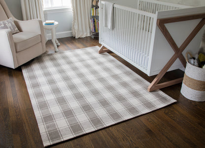 Gray and white plaid 2' x 8' runner on dark hardwood floor beside a white baby crib in a cozy nursery.